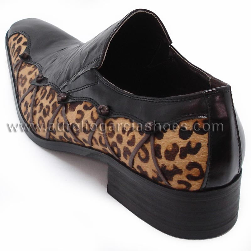 The FI-6676 Black Fiesso by Aurelio Garcia, a product from the brand Fiesso, is a stylish black leather shoe with leopard print accents, featuring a pointed toe design and a cushioned insole for enhanced comfort.