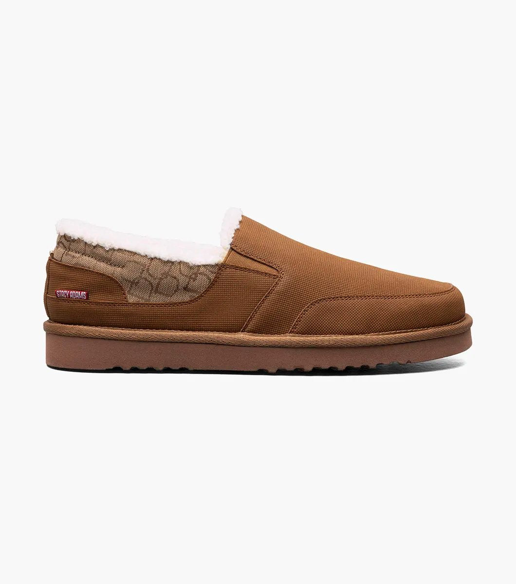 The Stacy Adams - COZE Moc Toe Slip On - Tan Multi - 25558-238, from STACY ADAMS, boasts a textured fabric exterior and soft faux shearling lining. It features a cushioned insole and a brown rubber sole.