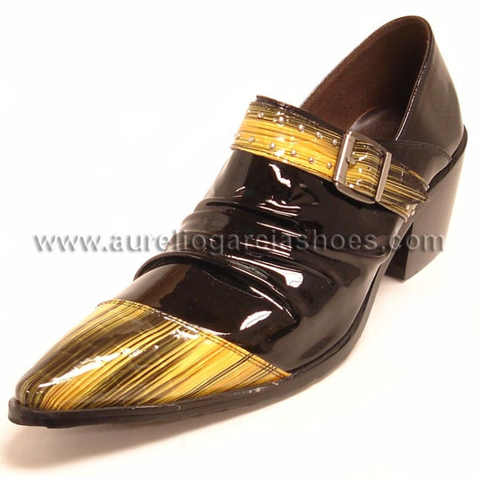 The FI-6785 Black Yellow Encore by Fiesso is a shiny black patent leather slip-on shoe with a low heel, adorned with gold detailing on the toe and a decorative buckle strap across the top.