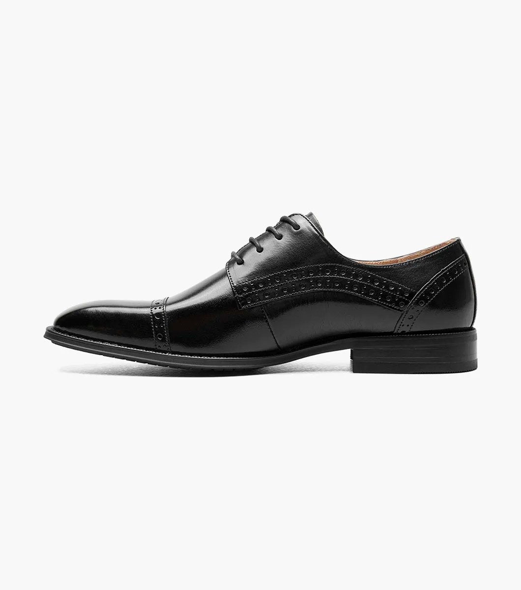 A Stacy Adams - GARRETT Cap Toe Oxford shoe in black leather, featuring decorative perforations, laces, and a luxurious Memory Foam insole, is shown on a white background.