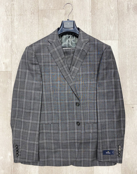 The Canaletto Grey/Plum Plaid Dolcetto Modern Fit Pure Wool Suit by Reda Cloth is elegantly crafted and displayed on a wooden hanger against a light wooden background.