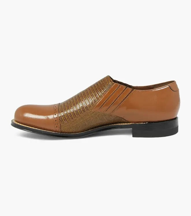 Stacy Adams presents the MADISON Cap Toe Slip On in tan, showcasing a leather upper with a textured pattern and brogue details, finished with a low black heel.