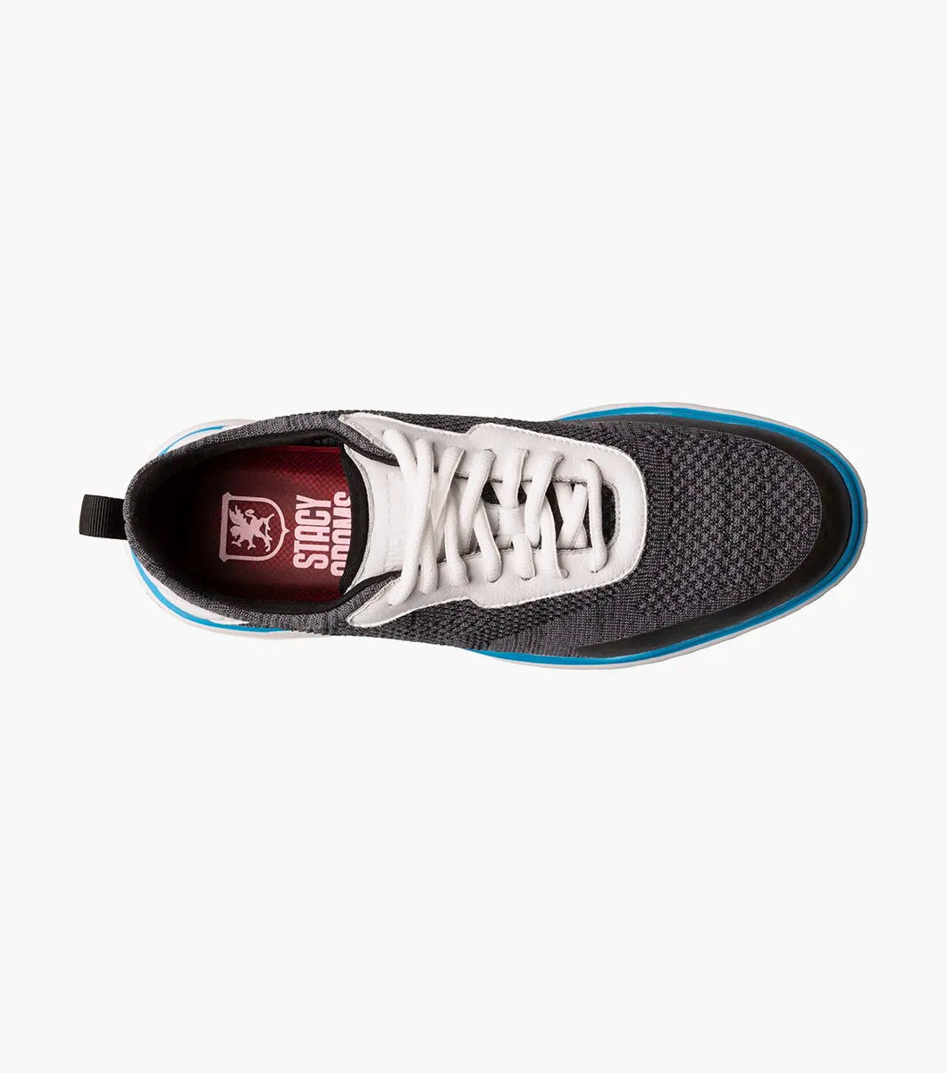 The Stacy Adams - MAXSON Moc Toe Lace Up Sneaker in Black Multi presents a stylish design with a white sole and blue accent, complemented by white laces and a textured mixed material upper for durability. This sneaker also provides anatomical arch support to ensure enhanced comfort with every step.