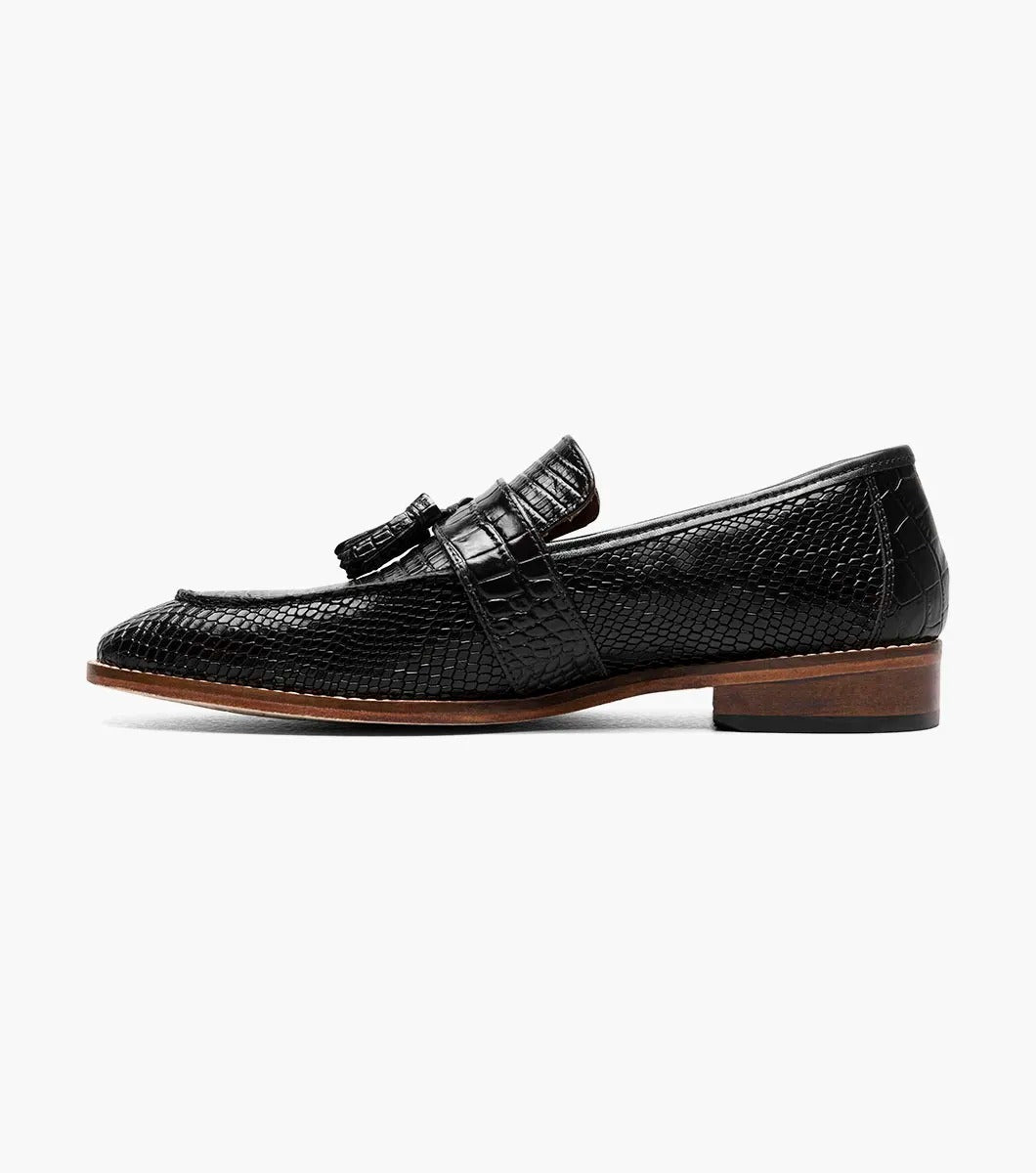 From the Stacy Adams PACETTI collection, this black leather Moc Toe Tassel Slip On loafer features a textured finish, memory foam insole, and brown sole against a white background.