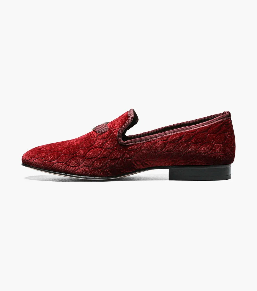 Introducing the Stacy Adams VALET Slip-On Bit Loafer in Burgundy (Product Code: 25166-601), this stylish footwear features a red velvet quilted pattern and is adorned with a gold emblem on the front. Crafted by STACY ADAMS, it boasts a genuine leather sole and incorporates a memory foam insole for enhanced comfort.