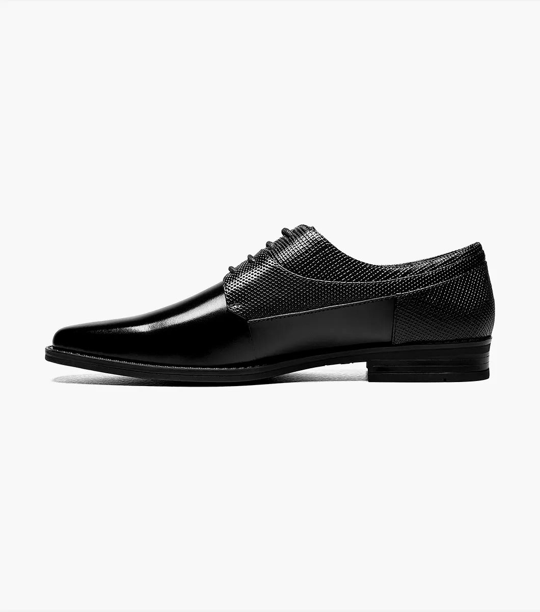 A single Stacy Adams Kirkley Plain Toe Oxford shoe in black, featuring a shiny finish and textured leather detailing on the sides.