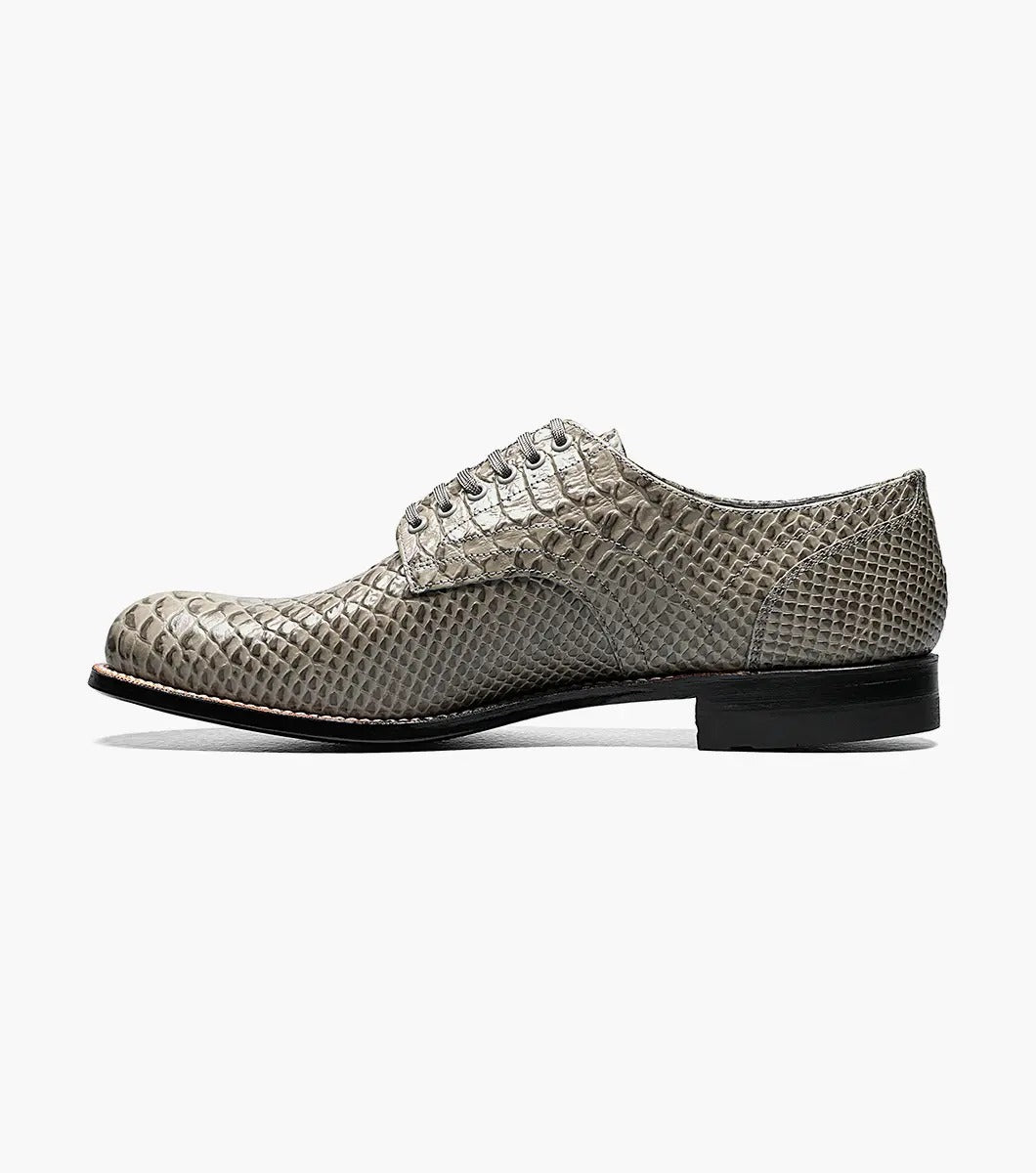 The Stacy Adams Madison Anaconda Plain Toe Oxford in gray showcases a sleek snakeskin pattern, complemented by a black leather outsole and matching laces, all elegantly displayed on a white background.