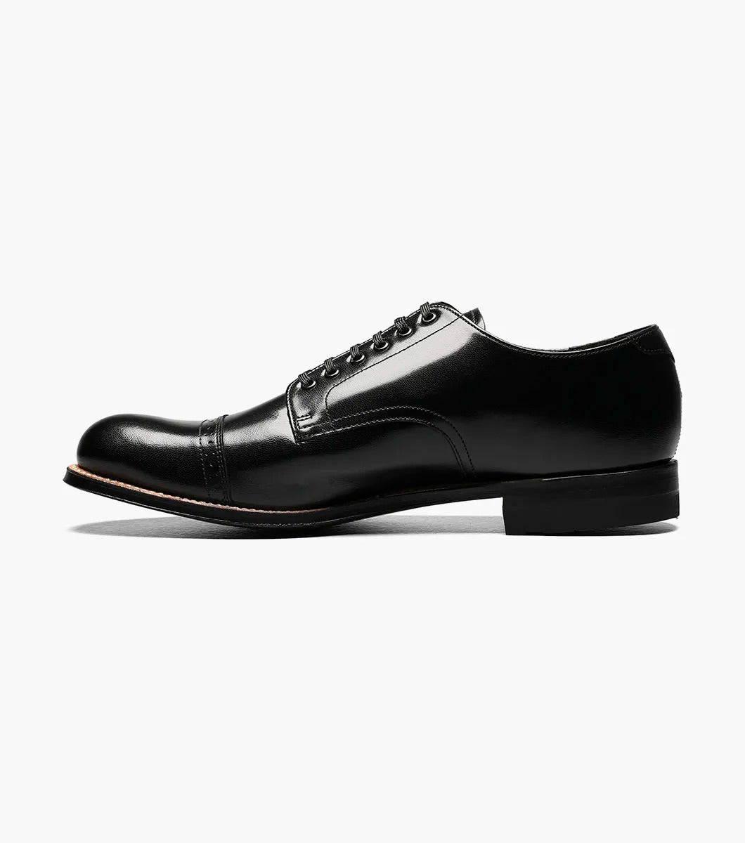 The Stacy Adams MADISON Cap Toe Oxford in black (product code: 00012-01) is a kidskin leather shoe with laces, presented against a pristine white background, and it boasts impeccable Goodyear welt construction for both durability and style.