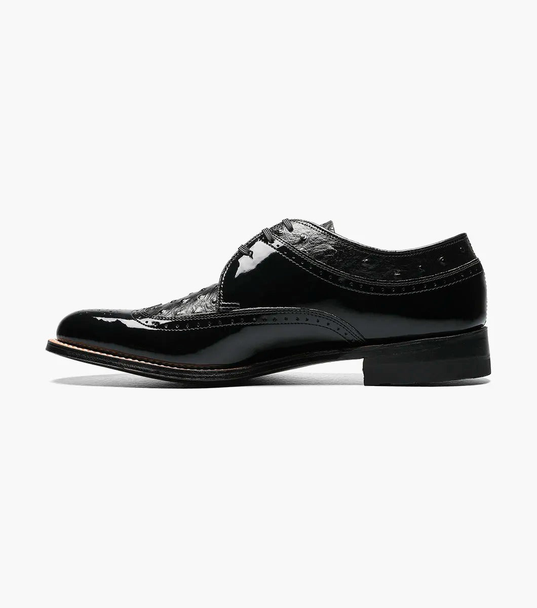 The Stacy Adams - DAYTON Ostrich Wingtip Oxford in black, style number 00375-01, is a single leather dress shoe with decorative perforations and a polished finish. It features laces and a slight heel.