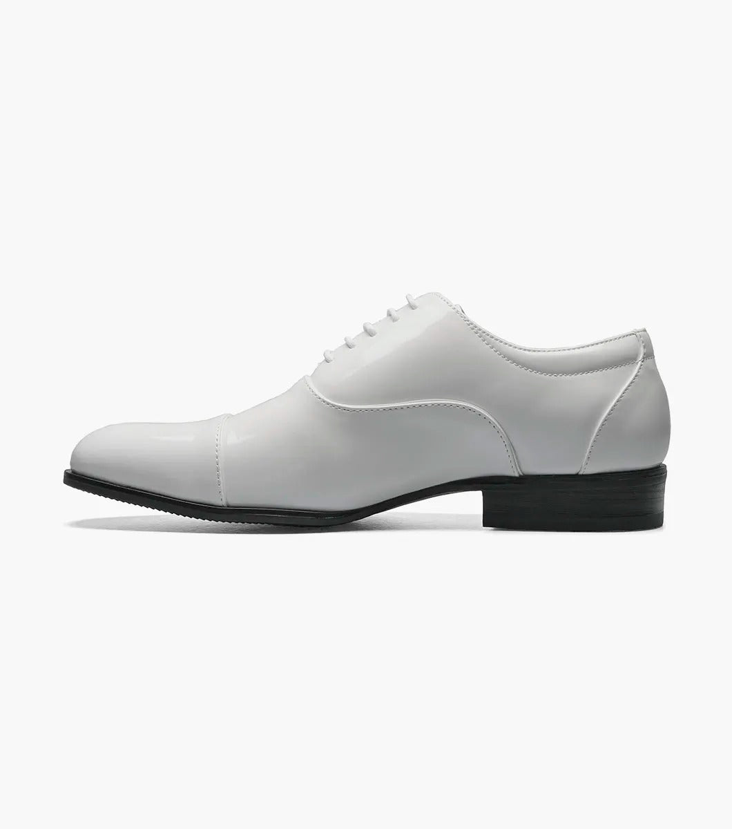 The Stacy Adams GALA Cap Toe Oxford in white patent leather, product number 24998-122, showcases a sleek cap toe design with black laces and a black sole, viewable from the side.