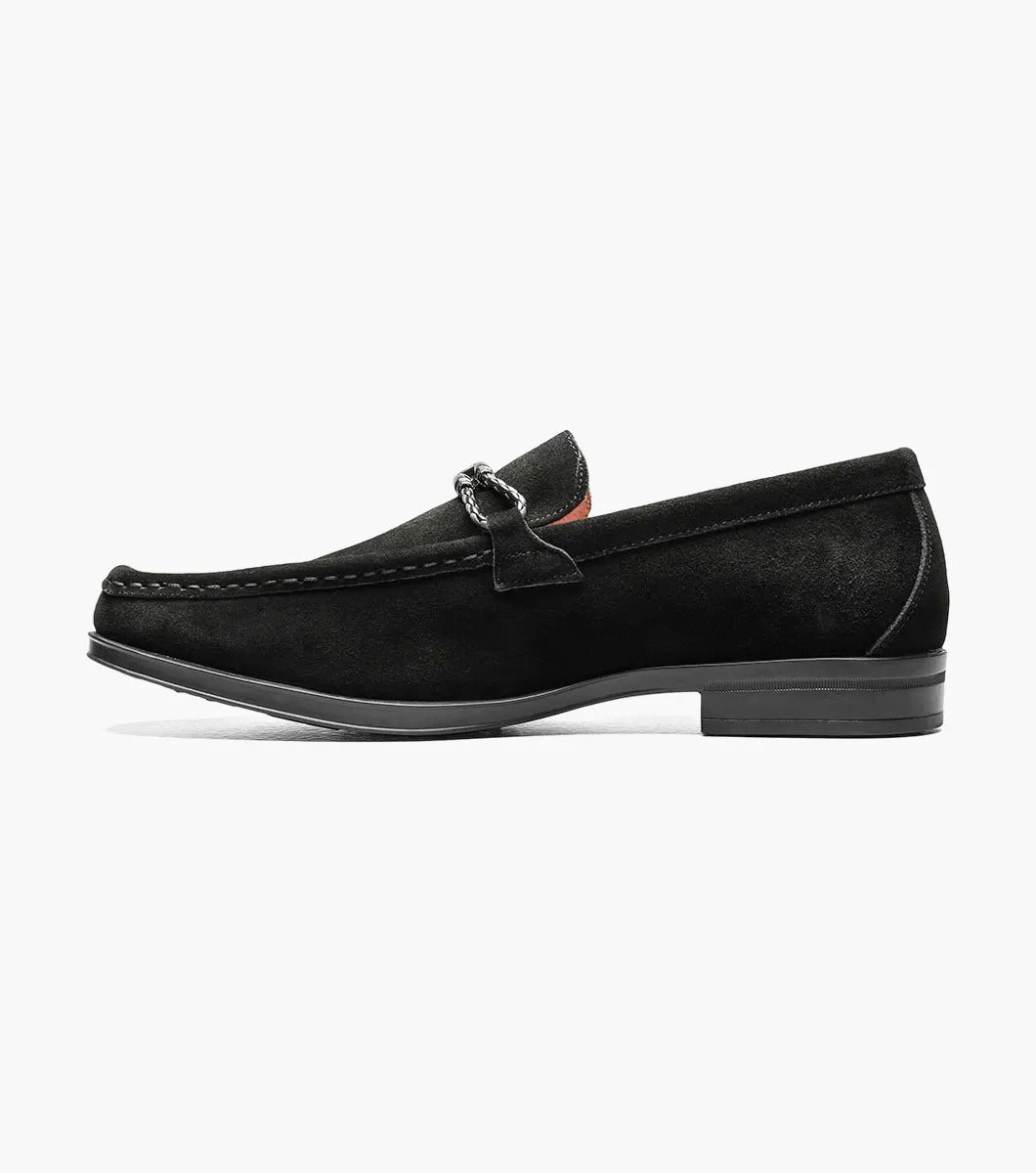 The Stacy Adams NEVILLE Moc Toe Bit Slip On in black suede showcases a metal chain detail on top, accompanied by a slightly elevated heel and stitched accents. Its cushioned insole provides comfort for all-day wear.