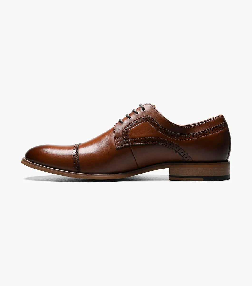 The Stacy Adams - DICKINSON Cap Toe Oxford in Cognac (25066-221) showcases a Leather Upper with decorative perforations, lace-up closure, and Memory Foam for enhanced comfort, all displayed on a white background.