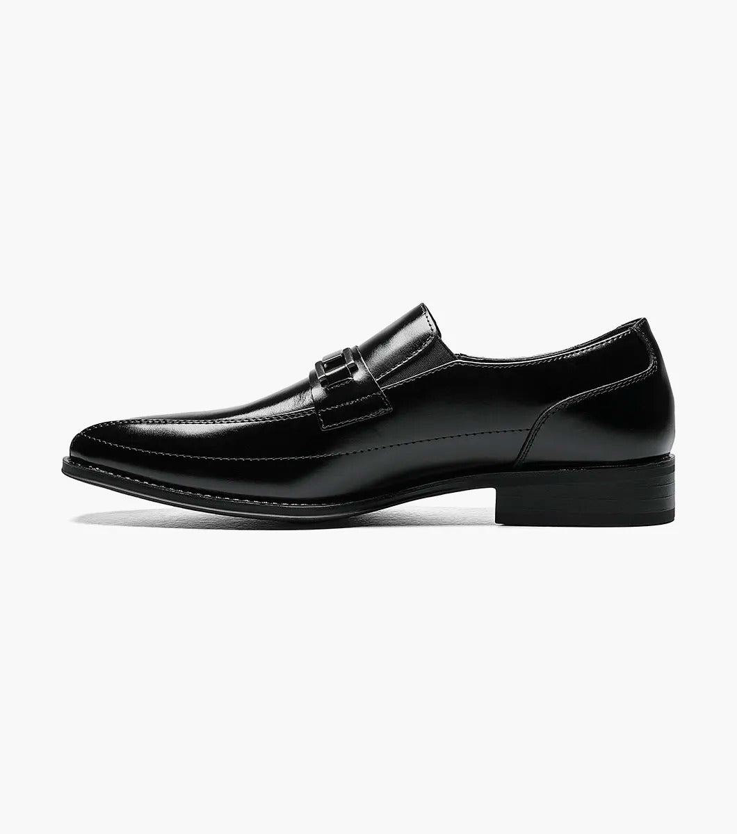 The Stacy Adams WAKEFIELD Bike Toe Bit Slip On in black is a sleekly designed leather men's dress shoe with a metallic decorative strap across the top and a cushioned footbed for added comfort. This perfectly crafted slip-on style offers easy wear.