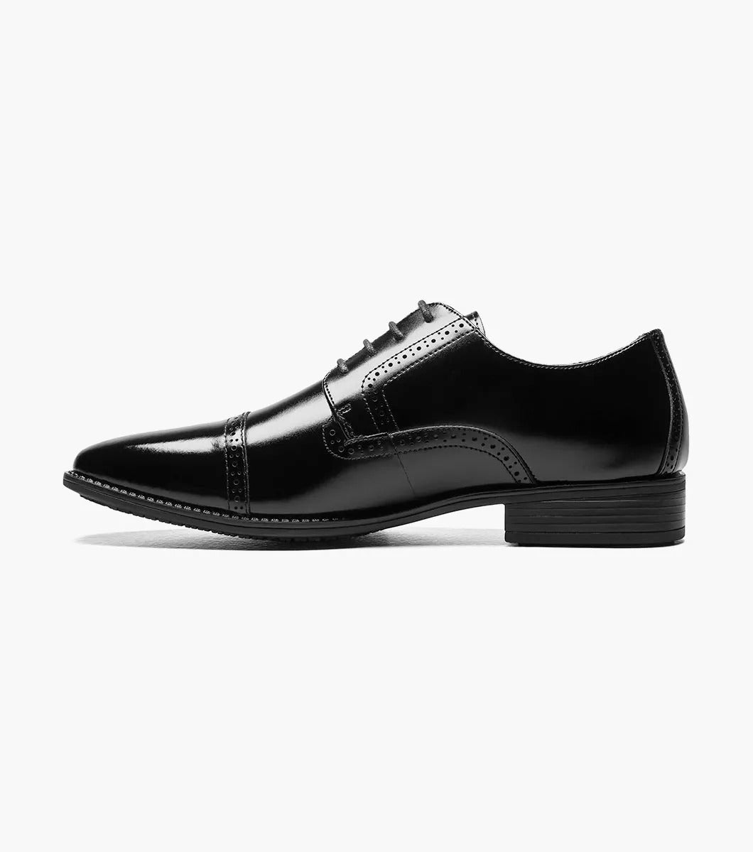 The STACY ADAMS - ABBOTT Cap Toe Oxford in Black (20159-001) is an elegant black dress shoe, made from genuine leather, with a stylish cap toe design, lace-up closure, and a slip-resistant sole, all beautifully showcased against a white background.