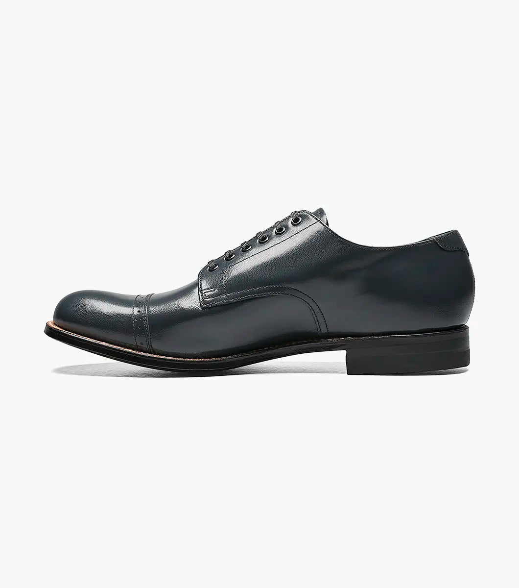 A refined Stacy Adams MADISON Cap Toe Oxford in navy, crafted from luxurious kidskin leather with elegant laces, features a polished cap toe design and a low heel against a white background.