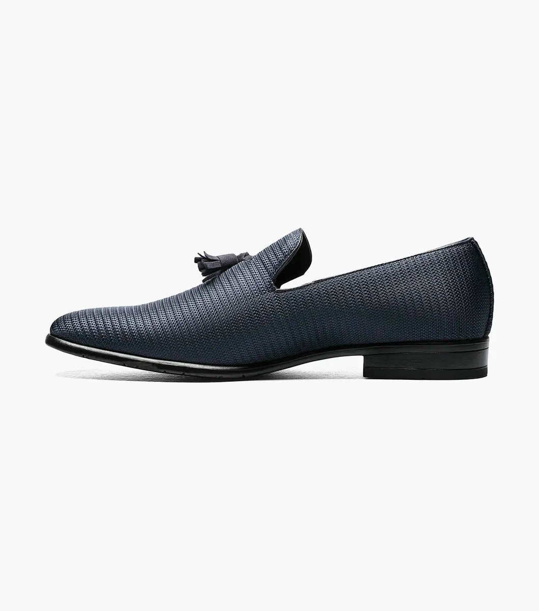 Here's a revised version of the sentence using the provided product data:

A single navy Stacy Adams TAZEWELL Plain Toe Tassel Slip-On loafer, identified by its tassel detail and textured finish, viewed from the side. This loafer features a low heel, sleek design, and cushioned footbed for added comfort.