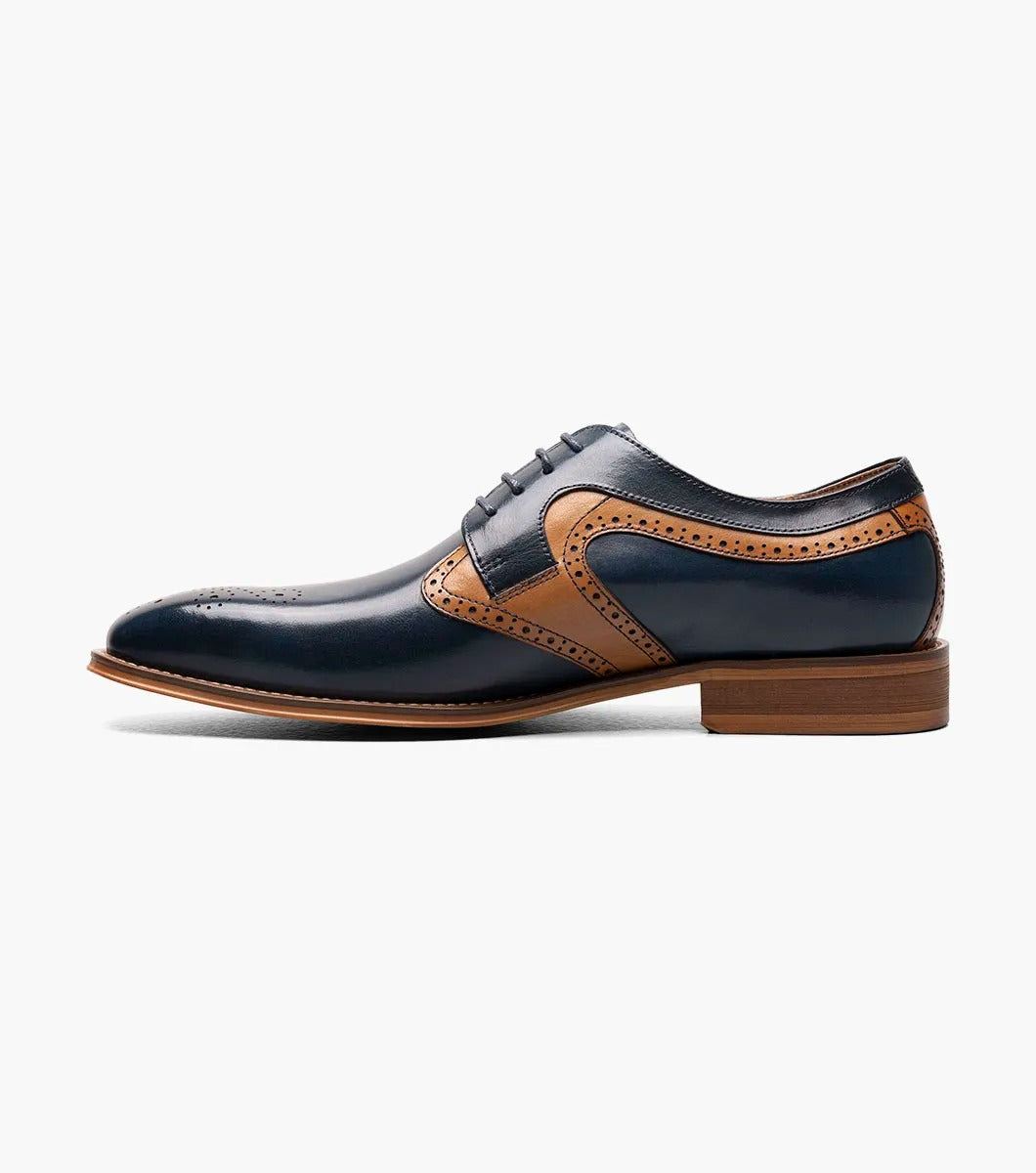 A side view of the Stacy Adams - PALMER Plain Toe Medallion Oxford showcases its navy and brown leather design, complete with decorative perforations and a wooden heel.