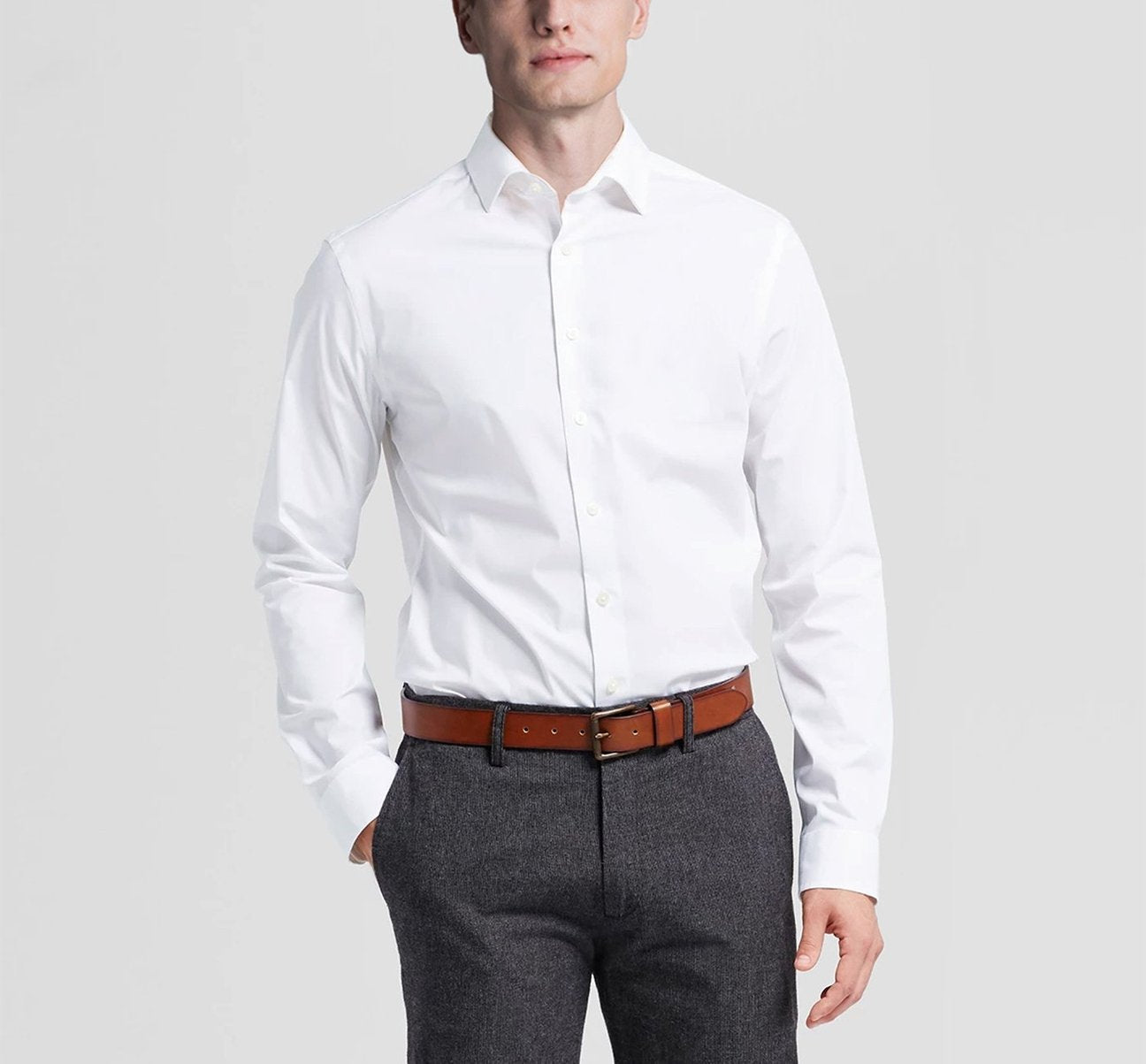 Folded dress shirt in white showcasing a regular classic fit complemented by long sleeves and a refined spread collar. A circular inset fabric detail enhances its elegance. The label states "Renoir.