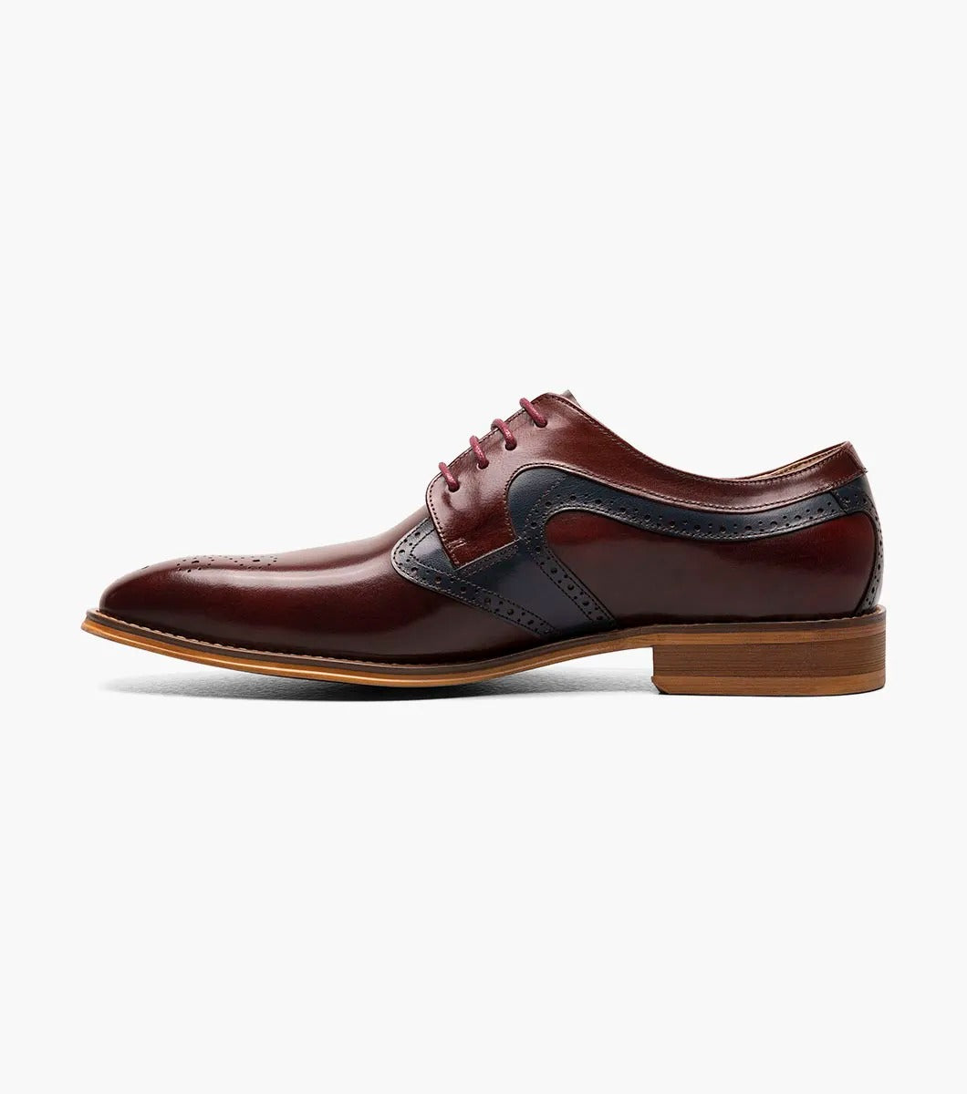 The STACY ADAMS Palmer Plain Toe Medallion Oxford in Burgundy Multi is an elegant men's dress shoe made from luxurious buffalo leather in burgundy and navy, featuring detailed perforations and a traditional wooden sole.