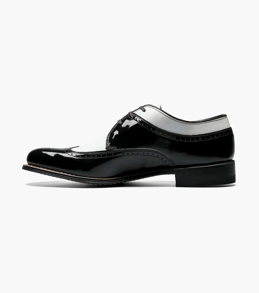 The Stacy Adams - DAYTON Snakeskin Wingtip Oxford in black and white is a sophisticated shoe from STACY ADAMS, expertly crafted from premium patent leather. It features a lace-up closure and classic Goodyear welt construction, set against a plain background.