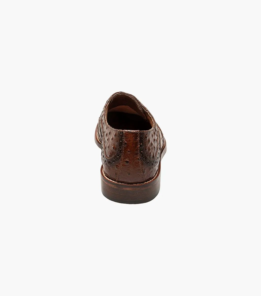 The Stacy Adams GENNARO Wingtip Oxford in Cognac, featuring elegant brogue detailing and a stylish wingtip design, is crafted from ostrich quill print leather and includes the RedZone removable footbed for superior comfort and support.