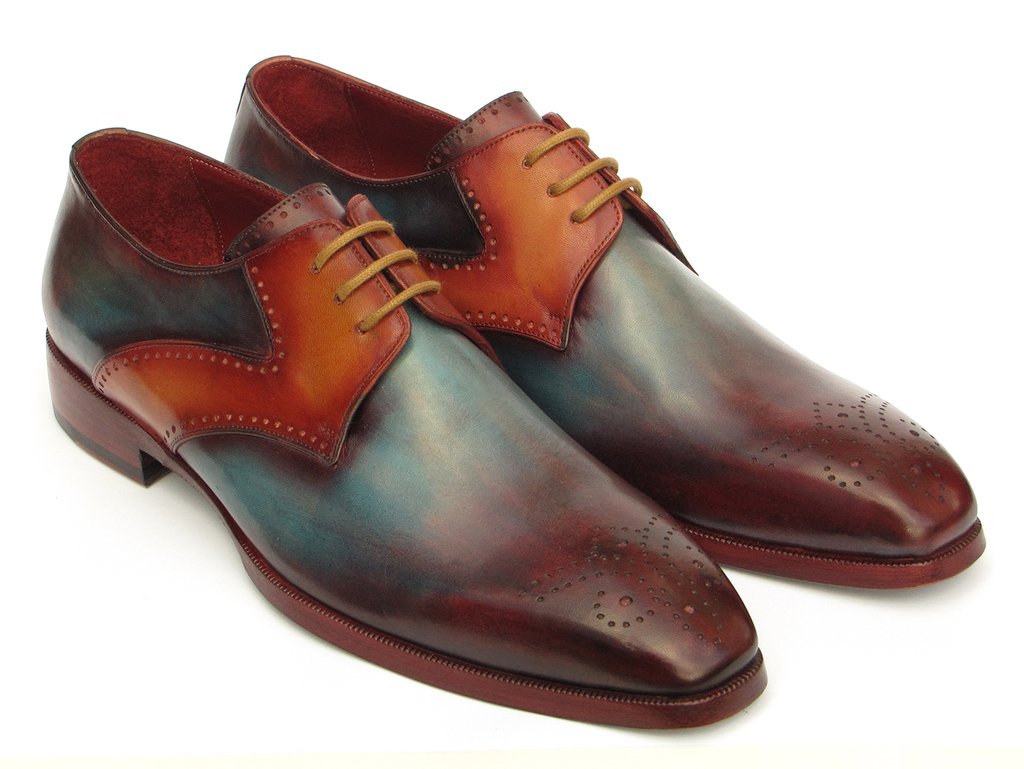 The Paul Parkman Multicolor Medallion Toe Derby Shoes (6584-MIX) are hand-painted dress shoes crafted in polished leather. They exhibit a captivating gradient of bordeaux, teal, and brown tones, featuring decorative perforations with a medallion toe design. These shoes are elegantly enhanced by brown laces.