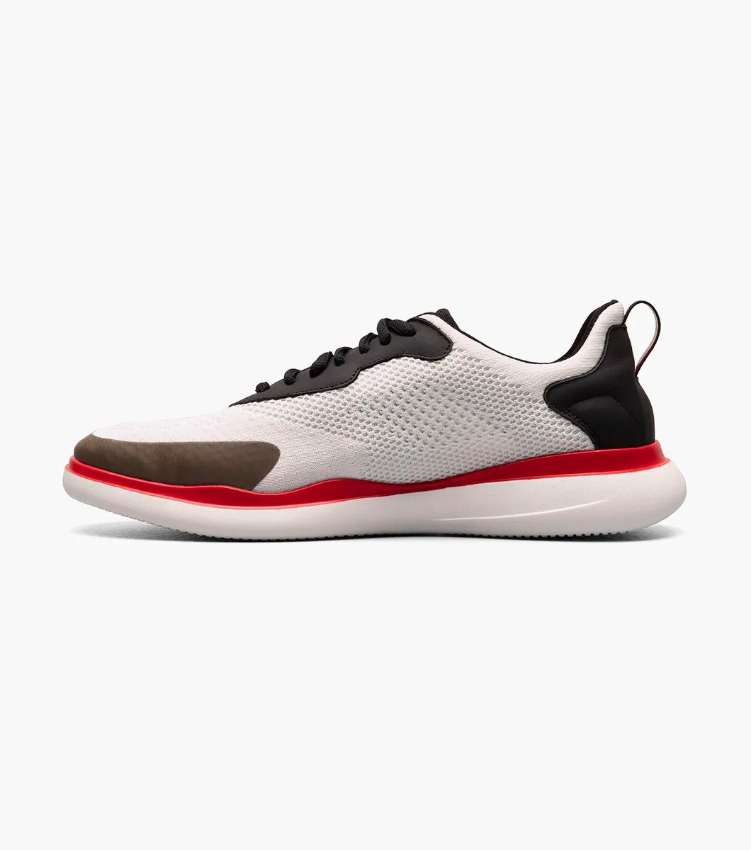 The Stacy Adams - MAXSON Moc Toe Lace Up Sneaker in White Multi (style 25517-110) showcases a sleek design with black accents, a striking red sole, and a distinctive brown toe cap. This hybrid sneaker-casual shoe provides both versatility and comfort, enhanced by the RedZone removable footbed for premium support.