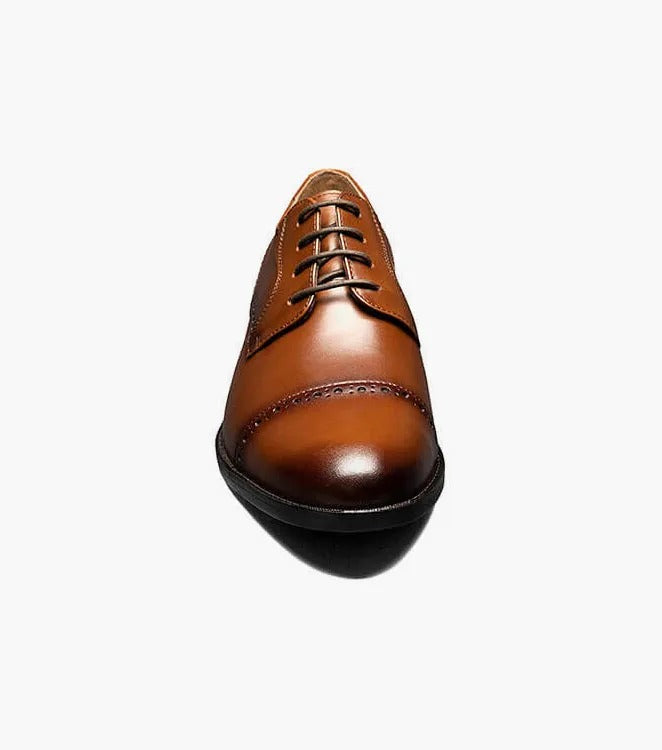 The Stacy Adams BARNETT Cap Toe Oxford in Scotch color, model 20196-232, is a classic brown burnished leather dress shoe with decorative stitching and laces. It features a low heel, smooth sole, and embodies the timeless elegance of a Cap Toe Oxford.