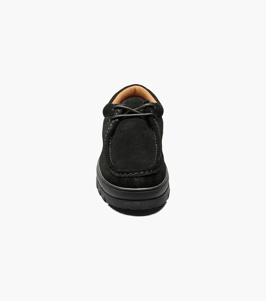 The Stacy Adams DETONATOR Moc Toe Chukka in black suede (63027-11) boasts soft suede material and laces, complemented by its oversized lug sole. Its thick, grooved rubber base enhances both style and comfort against a white background.