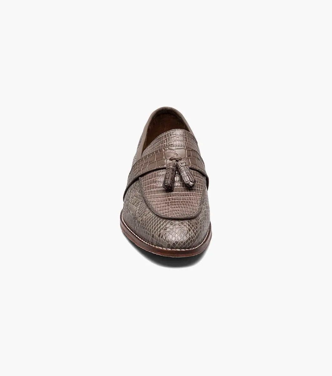 Gray tassel loafer designed by Stacy Adams, made from lizard print leather with dark brown trim and a low heel. It includes a Memory Foam insole for enhanced comfort and is displayed against a plain background.