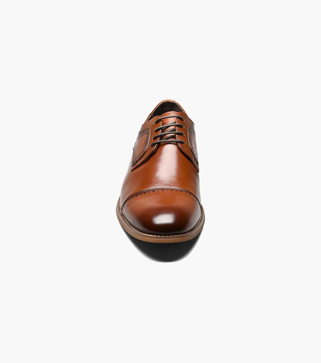 The Stacy Adams - DICKINSON Cap Toe Oxford in Cognac (25066-221) showcases a Leather Upper with decorative perforations, lace-up closure, and Memory Foam for enhanced comfort, all displayed on a white background.