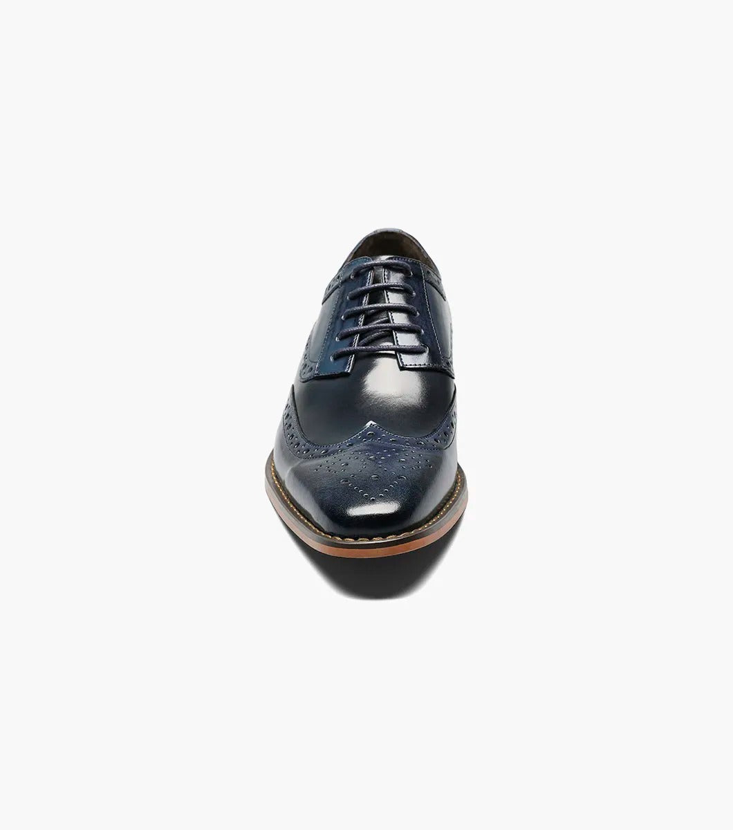 A Stacy Adams TINSLEY Wingtip Oxford in Cobalt Multi, featuring buffalo leather with decorative perforations, memory foam for added comfort, a wooden heel, and laces.