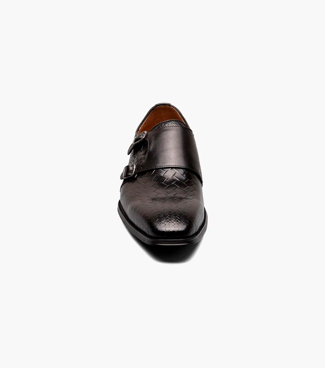 An angled view of the Stacy Adams - TORRANCE Plain Toe Double Monk Strap in Black offers a look at its black woven leather dress design, burnished finish, double monk strap, and low heel.