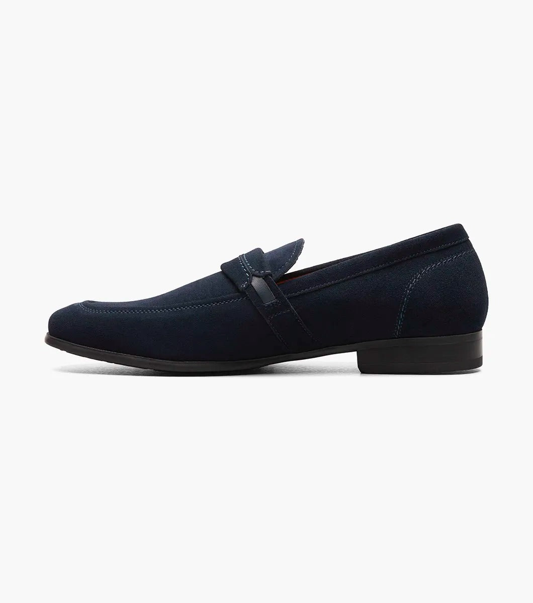 The Stacy Adams - QUILLAN Moc Toe Ornament Slip On features navy suede with a durable rubber outsole, embellished with a small metal buckle and complemented by a low black heel.