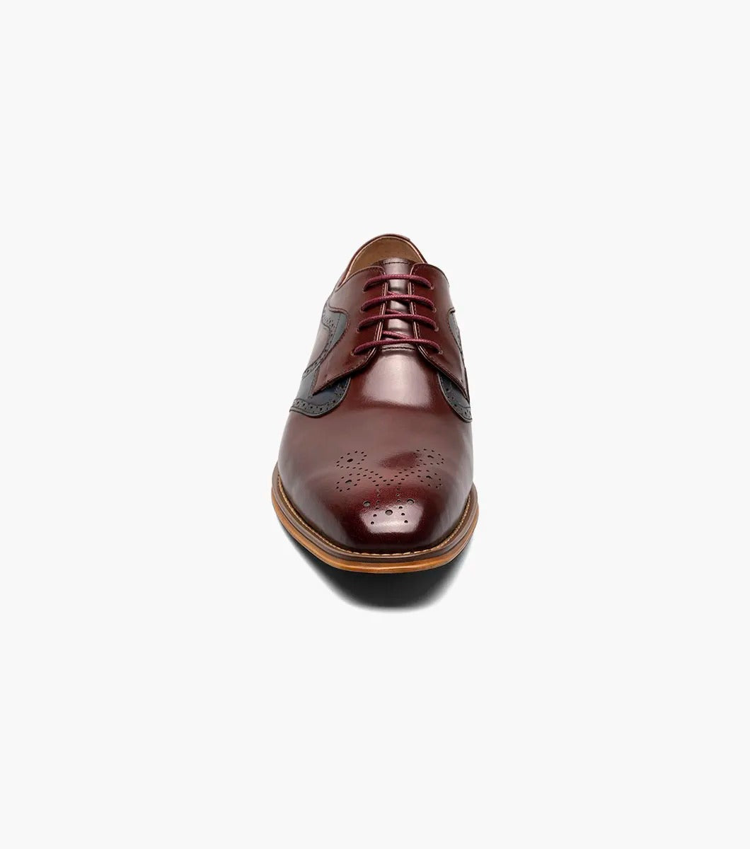 The STACY ADAMS Palmer Plain Toe Medallion Oxford in Burgundy Multi is an elegant men's dress shoe made from luxurious buffalo leather in burgundy and navy, featuring detailed perforations and a traditional wooden sole.