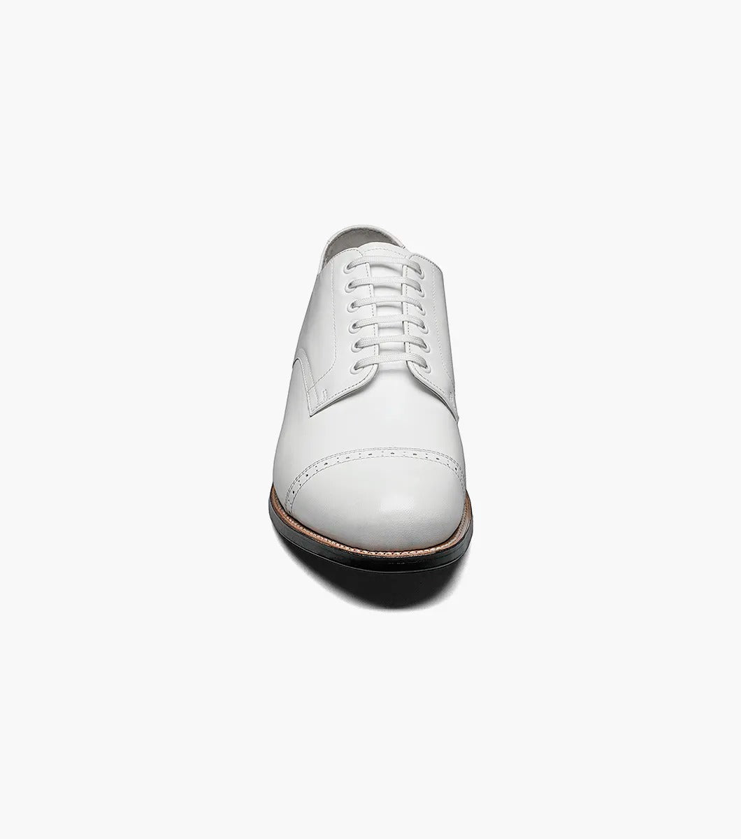 The MADISON Cap Toe Oxford in white, featuring sleek and stylish laces along with a contrasting black sole, embodies the timeless elegance for which STACY ADAMS is renowned.