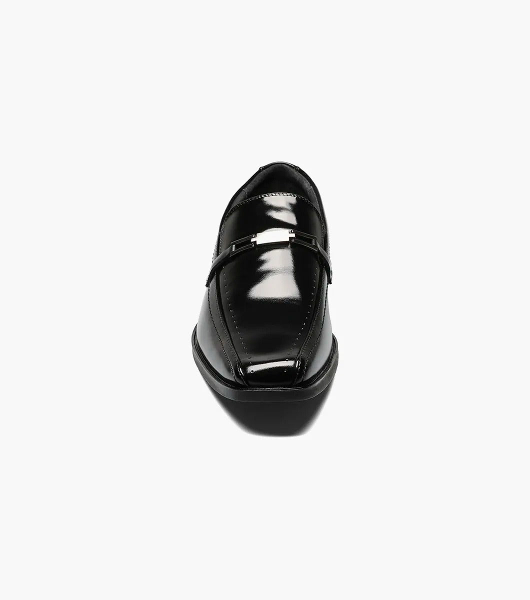 The Stacy Adams CADE Bike Toe Slip On in black, model 20126-001, is a stylish black leather loafer with a slip-on design. It features a gunmetal bit and a low heel, set against a plain white background.