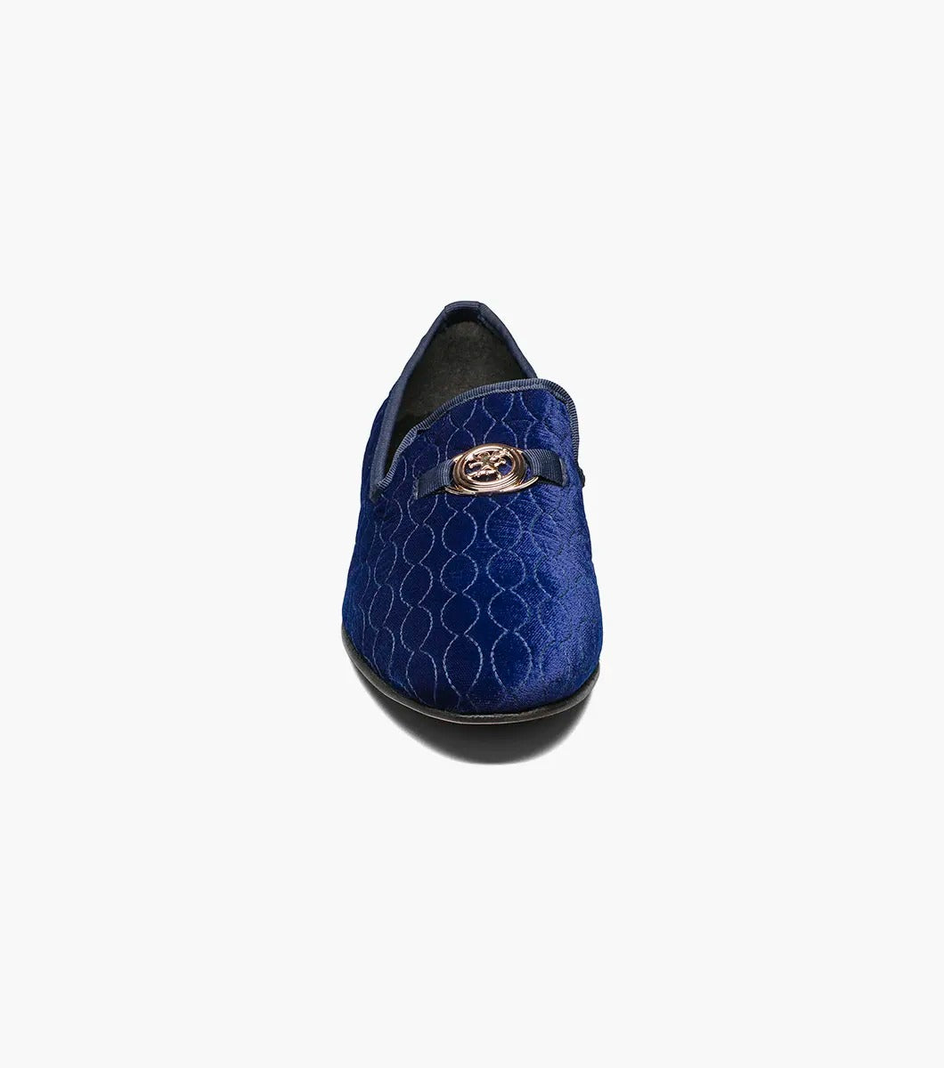 The Stacy Adams VALET Slip On Bit Loafer, model 25166-400, combines quilted velour in a striking blue with a sleek black sole and is elegantly decorated with a gold emblem on top. It also features a Memory Foam insole for enhanced comfort.