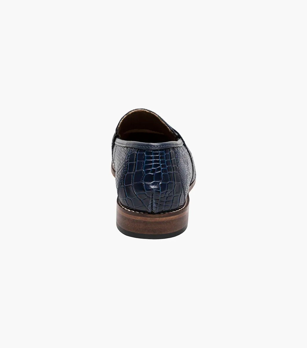 The Stacy Adams PACETTI Leather Sole Moc Toe Tassel Slip On in blue features a textured design with a memory foam insole and a brown sole.