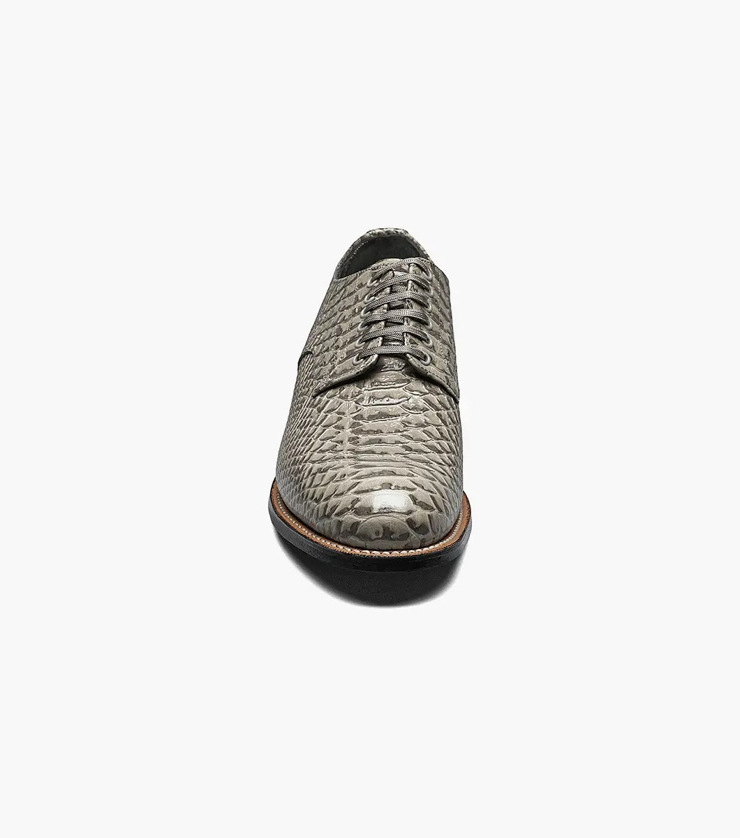 The Stacy Adams Madison Anaconda Plain Toe Oxford in gray showcases a sleek snakeskin pattern, complemented by a black leather outsole and matching laces, all elegantly displayed on a white background.