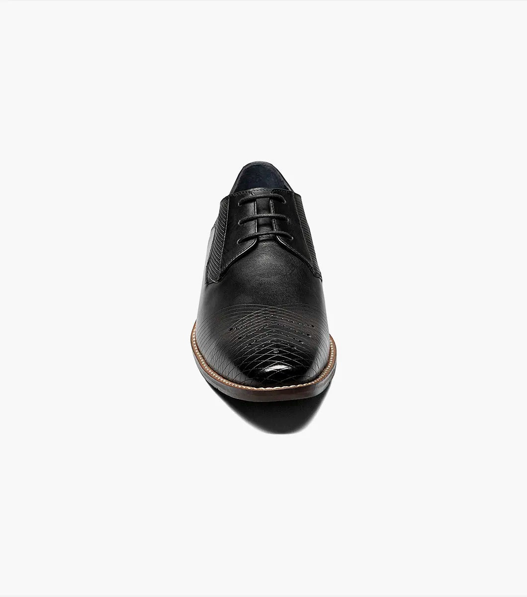 The Stacy Adams - JOVIAN Plain Toe Laser Oxford in black, product code 25504-001, is a premium dress shoe boasting a lace-up closure and distinctive brown detailing on the sole. Made from laser-treated leather for a sleek finish, it includes a Memory Foam insole to enhance comfort.