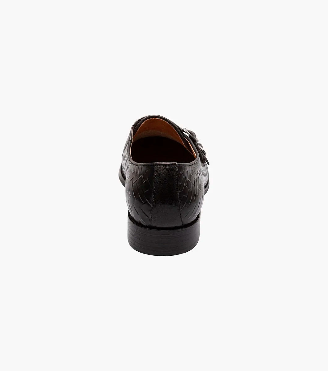 An angled view of the Stacy Adams - TORRANCE Plain Toe Double Monk Strap in Black offers a look at its black woven leather dress design, burnished finish, double monk strap, and low heel.