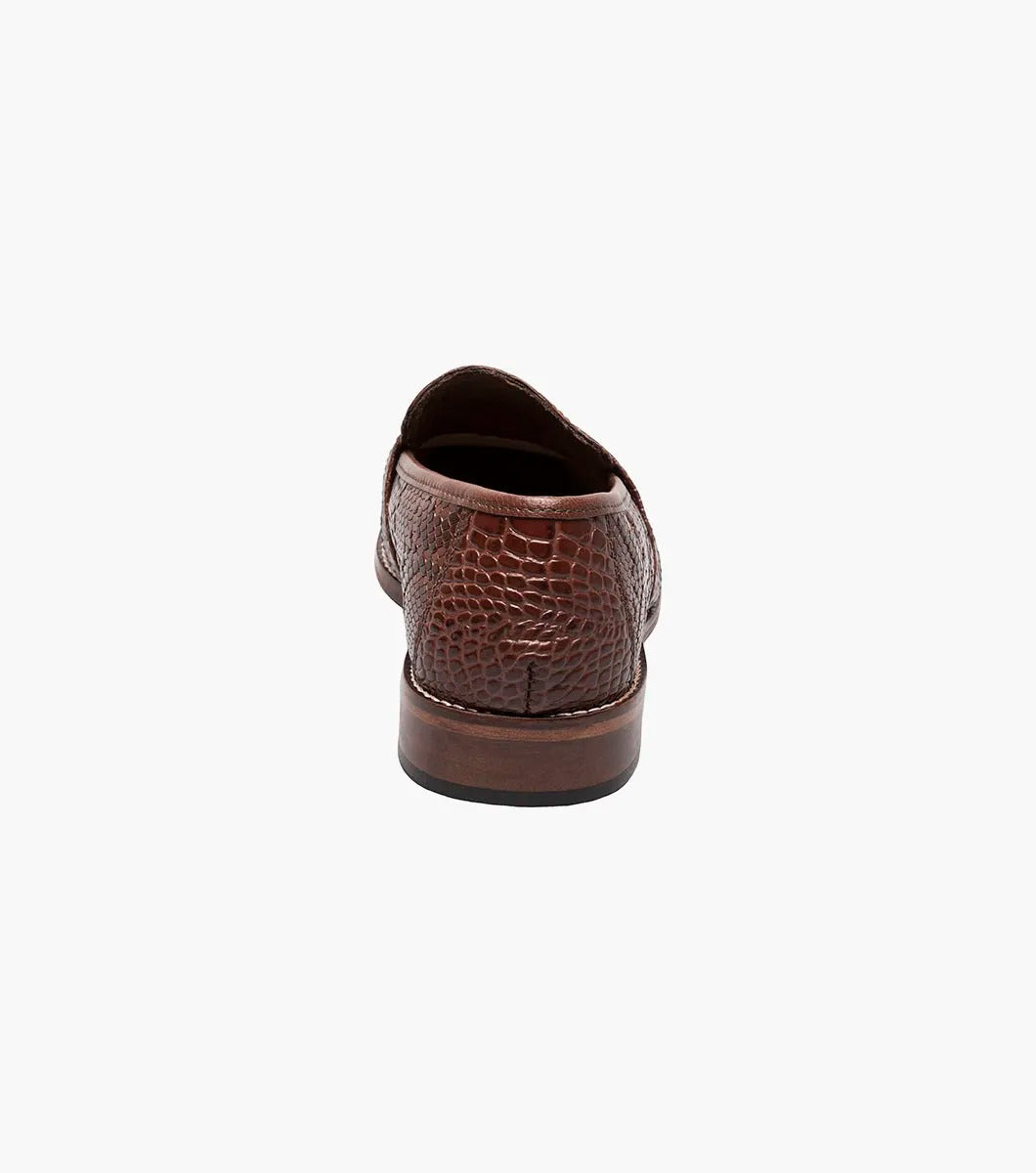 The Stacy Adams - PACETTI Leather Sole Moc Toe Tassel Slip On in Cognac, featuring a textured pattern with tassels on the front and a comfortable memory foam insole, is displayed against a plain white background.