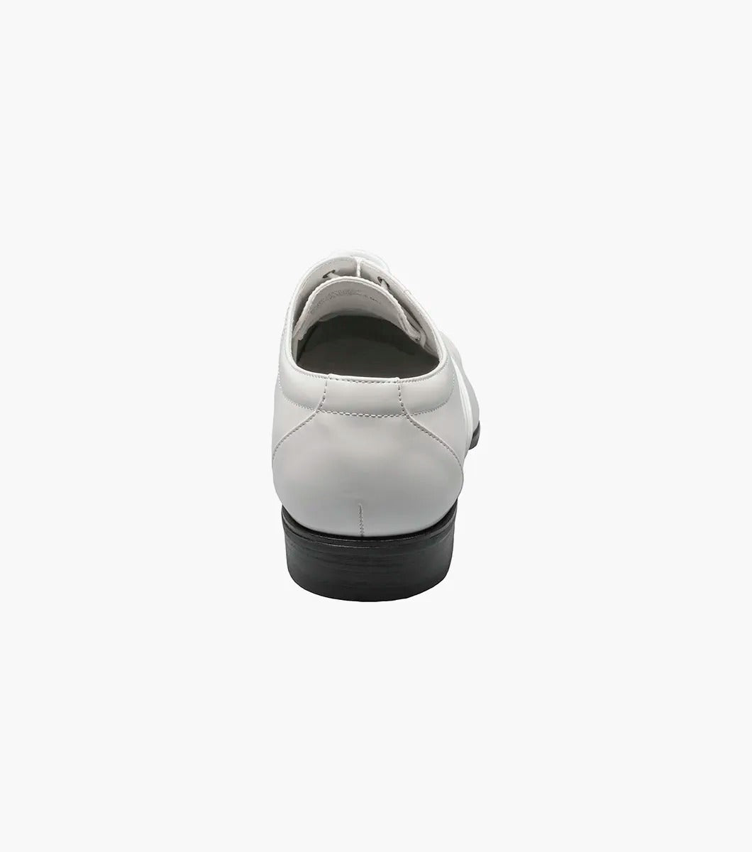 The Stacy Adams GALA Cap Toe Oxford in white patent leather, product number 24998-122, showcases a sleek cap toe design with black laces and a black sole, viewable from the side.