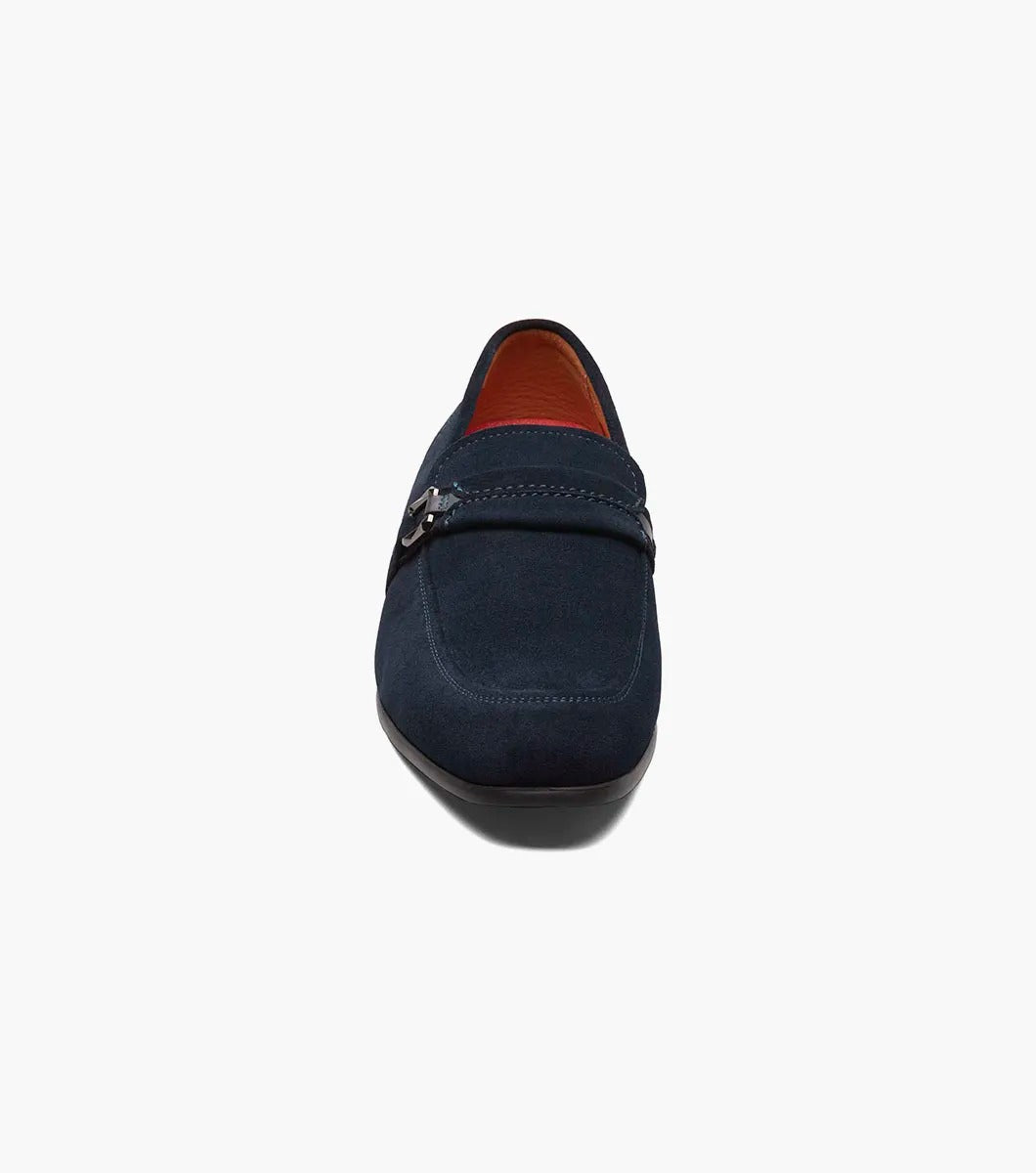 The Stacy Adams - QUILLAN Moc Toe Ornament Slip On features navy suede with a durable rubber outsole, embellished with a small metal buckle and complemented by a low black heel.