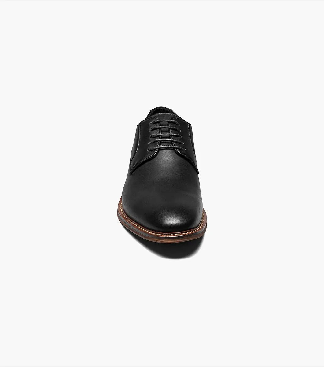 A single Stacy Adams - MARLTON Plain Toe Oxford in black leather, featuring laces, a burnished finish, brown sole, slight heel, and anatomical arch support is displayed on a plain white background.