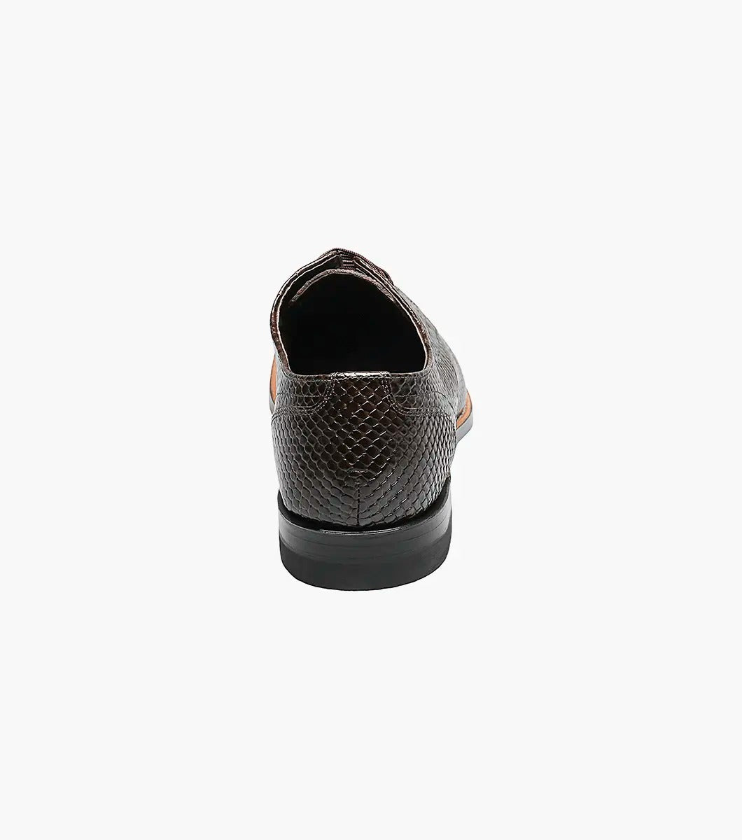 The Stacy Adams MADISON Anaconda Plain Toe Oxford in brown showcases an anaconda print with black laces, set against a white background.