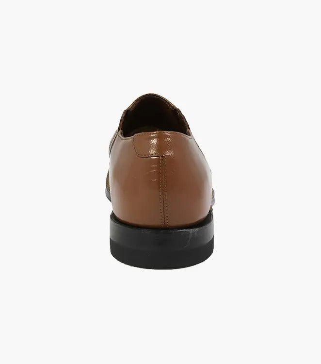 Stacy Adams presents the MADISON Cap Toe Slip On in tan, showcasing a leather upper with a textured pattern and brogue details, finished with a low black heel.