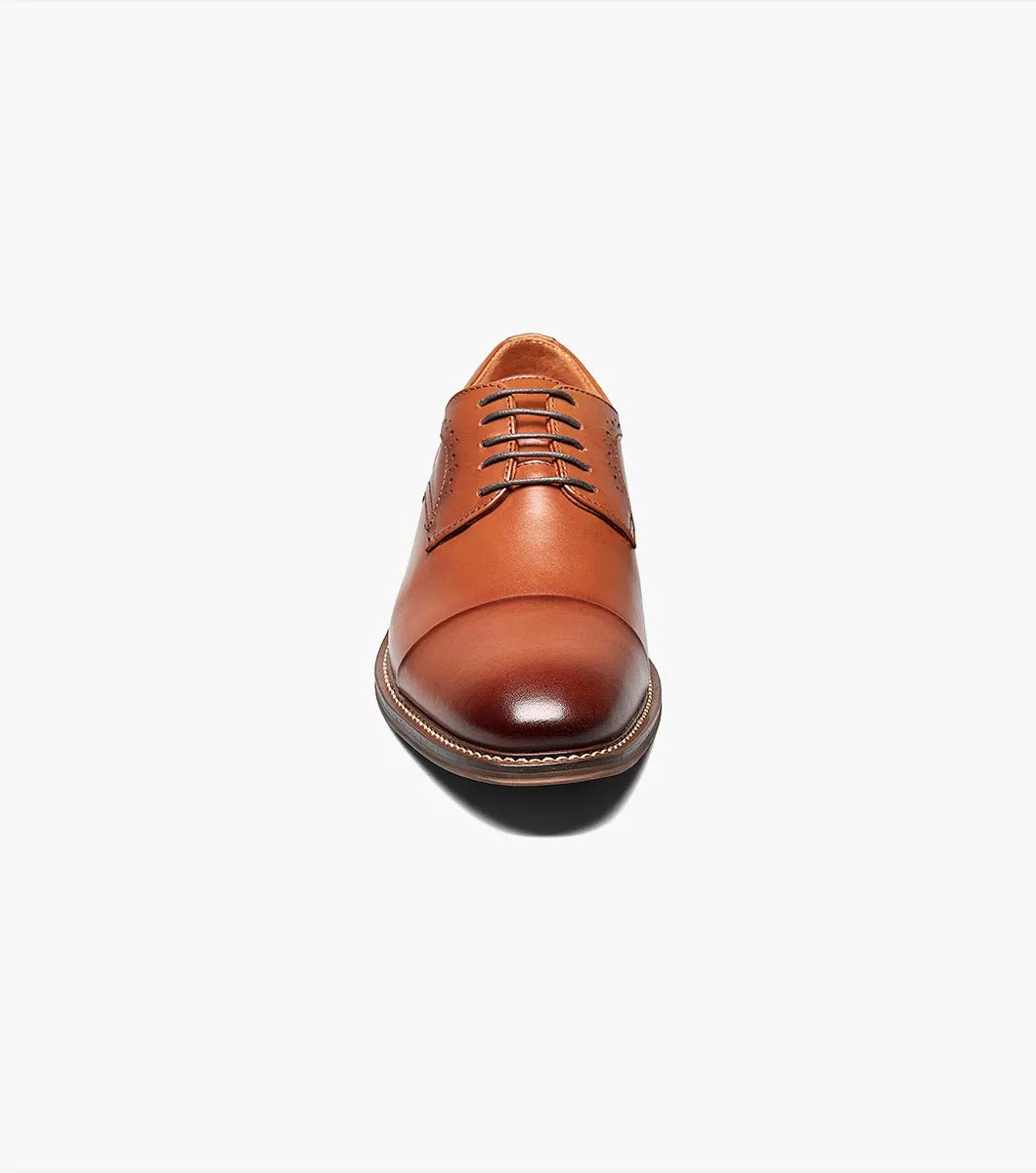 The Stacy Adams MADDOX Cap Toe Oxford in Cognac boasts a burnished leather finish, enhanced with a stylish cap toe and decorative perforations on the sides.