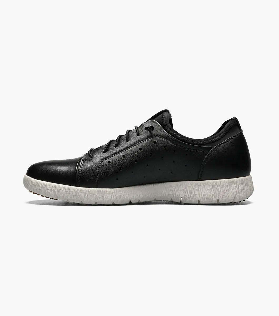 The Stacy Adams - HALDEN Lace Up Sneaker in black showcases a burnished leather upper and perforated side details, set against a plain white backdrop. It features a white rubber sole and cushioned footbed for optimal comfort.